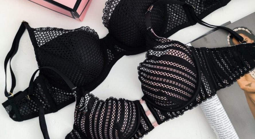 Elegant black bras with mesh designs, one padded, one unpadded, displayed with a pink box.