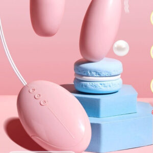 Vibratore a doppia testa Durex in rosa con macarons, in mostra prodotti per l'intimità lussuosi e giocosi.