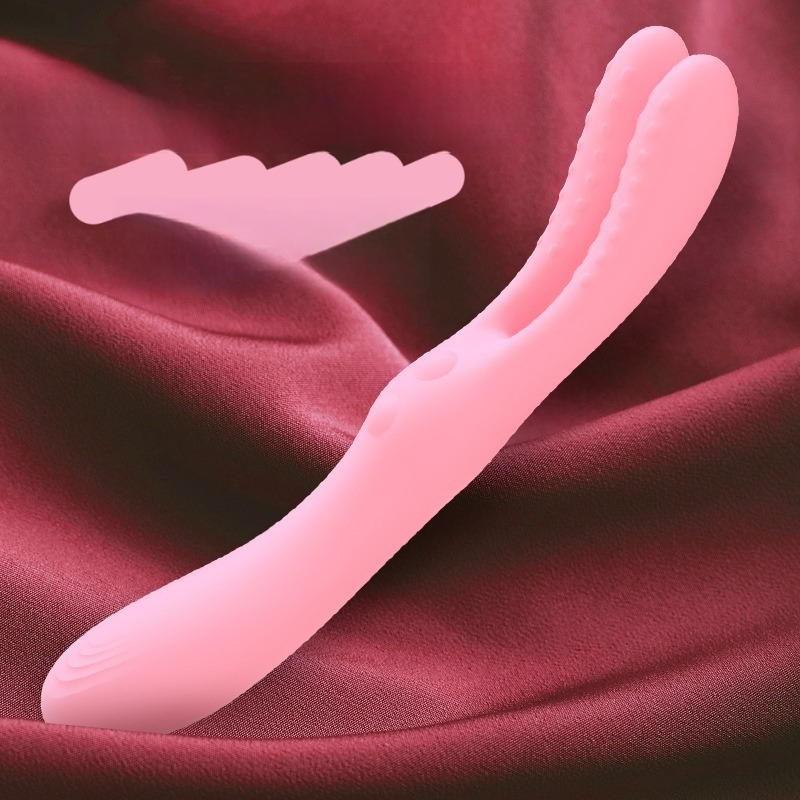 Vibrador de doble punta de silicona rosa sobre un rico tejido rojo, perfecto para el placer sensual y la exploración.