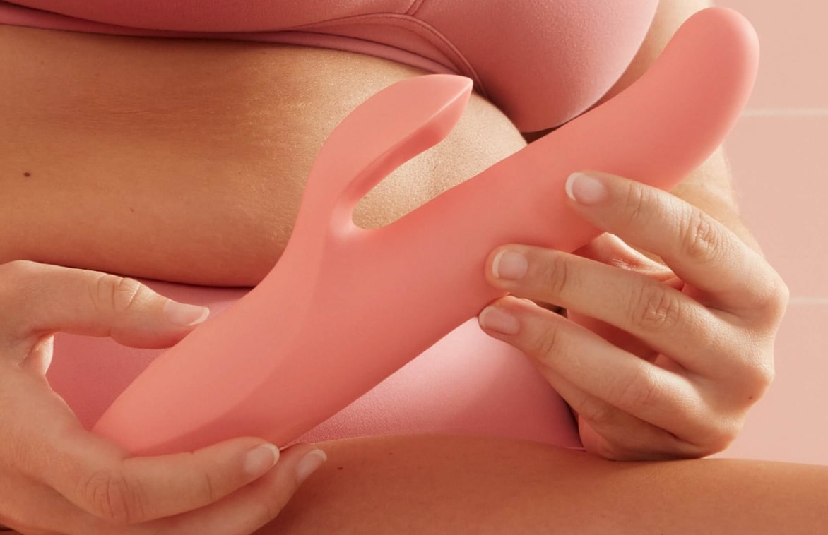 Grande plano de um brinquedo sexual de silicone cor-de-rosa, que mostra elegância e conforto num ambiente íntimo.