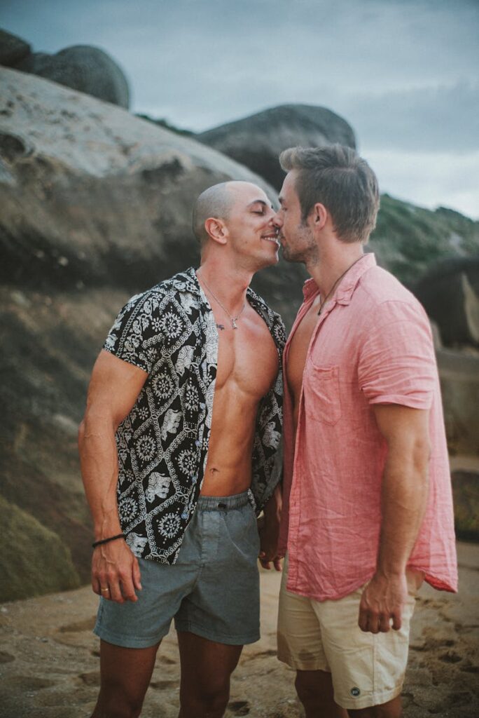 Two men sharing a tender moment on a picturesque beach, embodying love and togetherness.