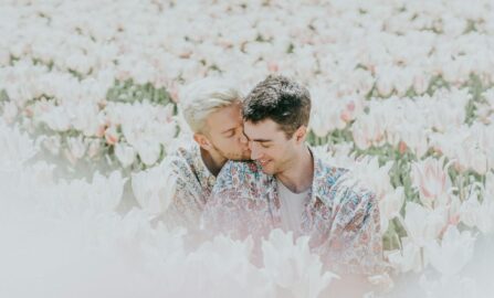 Un bacio romantico in un campo di tulipani Una coppia gioiosa che condivide un momento di tenerezza in un campo di tulipani illuminato dal sole.