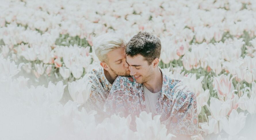 A joyful couple sharing a tender moment in a sunlit tulip field.