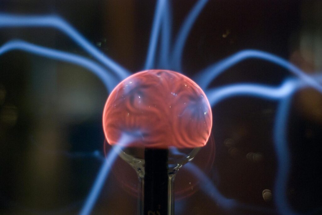 Close-up view of a plasma ball exhibiting mesmerizing electric arcs in a dark setting.