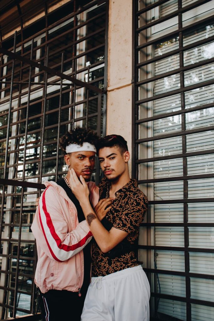 A glamorous photoshoot featuring a fashionable gay couple posing together in an urban setting.