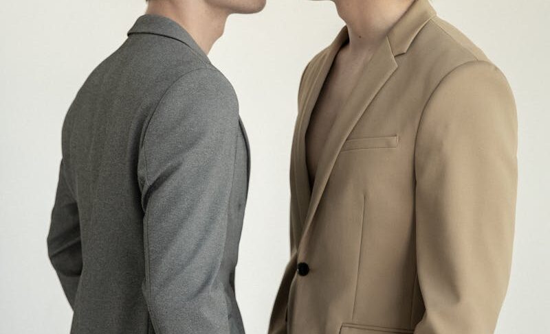 Stylish portrait of a couple in suits wearing flower crowns, showcasing love and elegance.