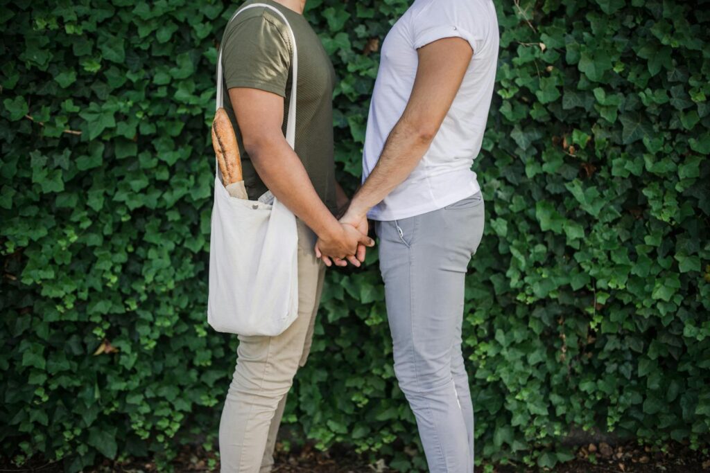 Two Men Standing Face To Face and Holding Hands