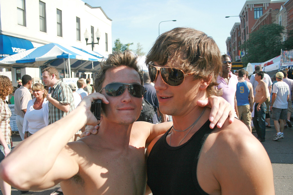 Joyful friends share a playful moment at a summer festival, embracing friendship and celebration under the sun.