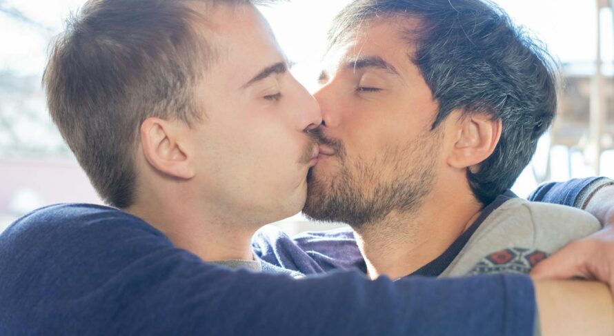 A loving moment captured between two men kissing, symbolizing affection and intimacy.