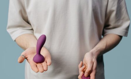 Embracing Intimacy: Современный подход к самоисследованию Взрослый держит в руках два разных фиолетовых вибратора, пропагандируя любовь к себе и сексуальное благополучие.