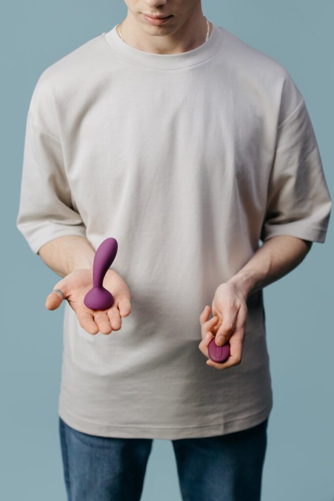 Adult holding two different purple vibrators, promoting self-love and sexual wellness.