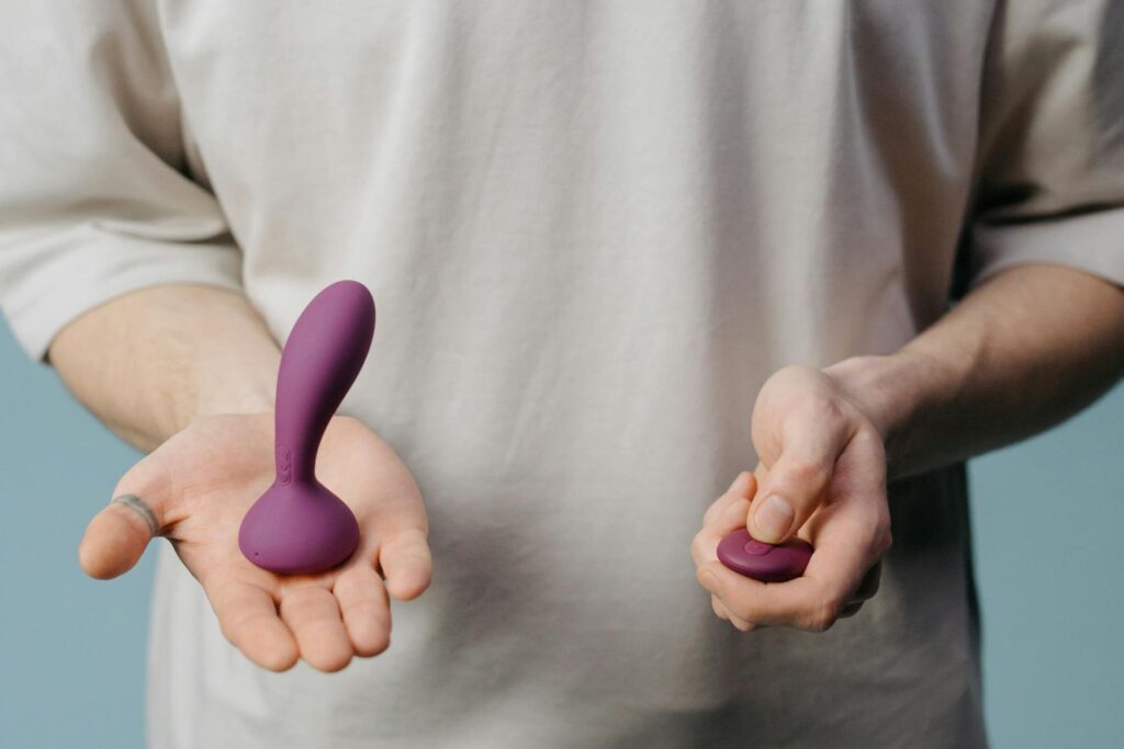 Close-up of hands holding a purple sex toy, highlighting sensuality and self-care.