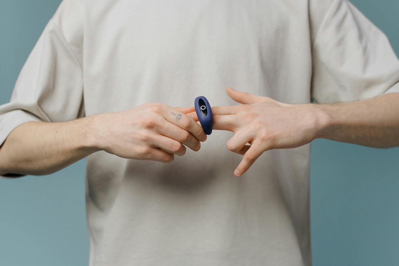 Mand demonstrerer et personligt wellness-apparat med fokus på kropspleje og selvkærlighed.