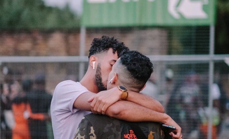 shallow focus photo of two men kissing