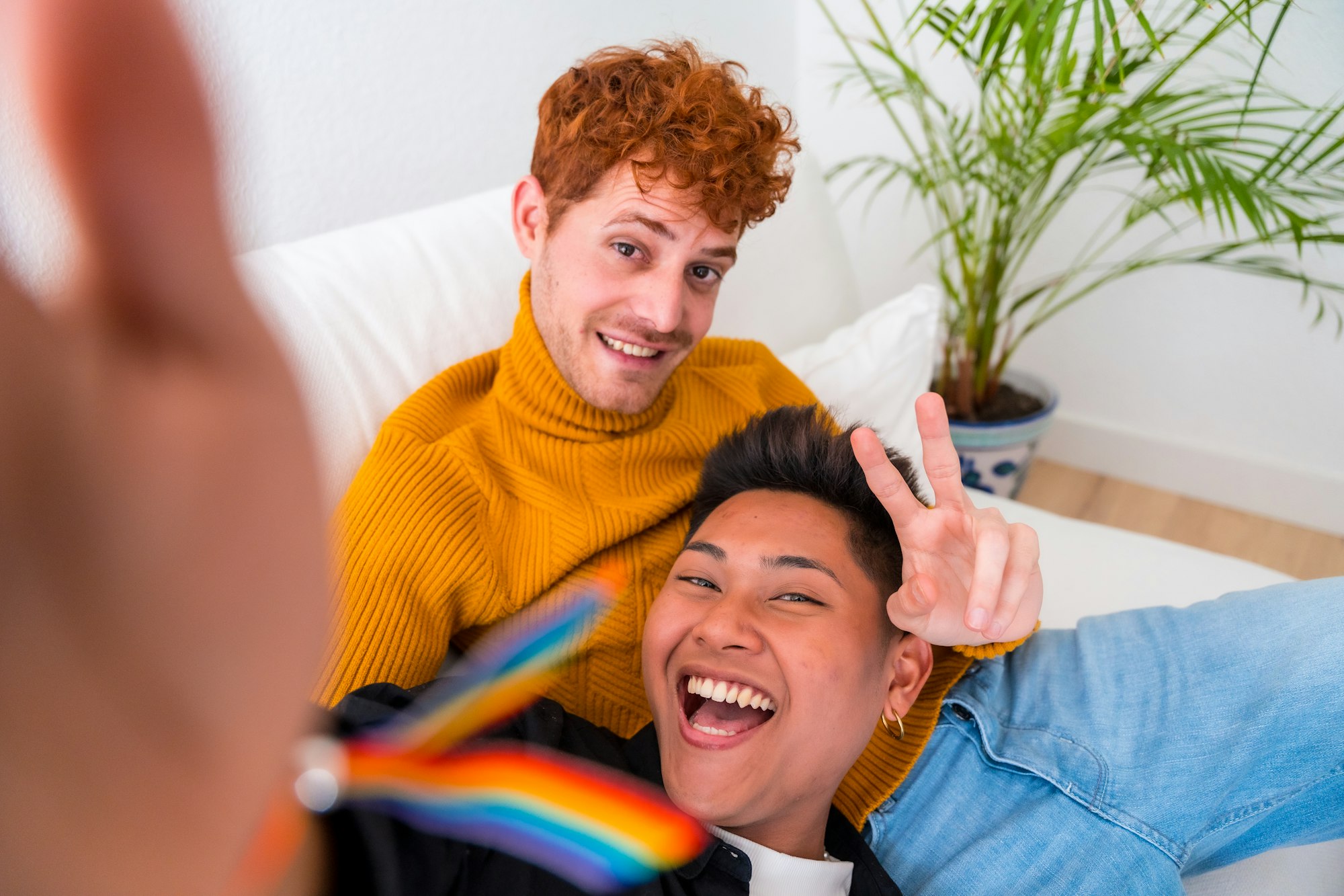 Bella coppia gay essere romantico in casa sul divano, coppia gay prendere selfie e fare