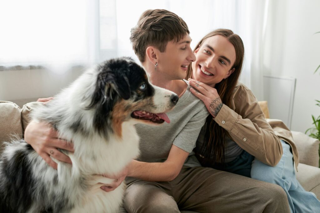 Cheerful and long haired gay man with tattoo on hand hugging and looking at young boyfriend