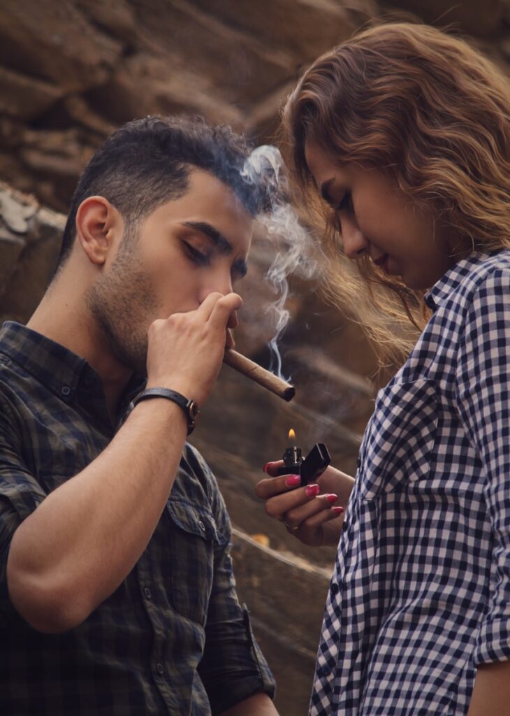 un hombre y una mujer fumando un cigarrillo