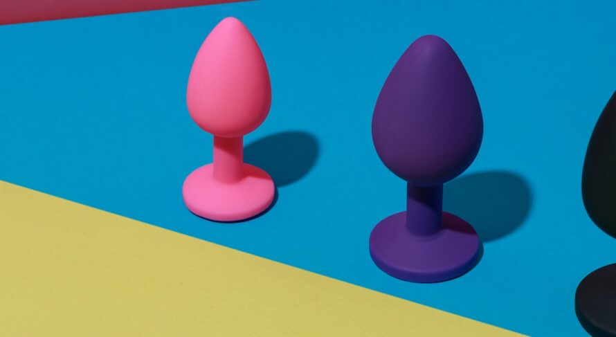 Vibrant Anal Toys Against a Bold Geometric Background Different colored buttplug sex toys with contrast shadows. Anal toys for adult. Sex shop concept