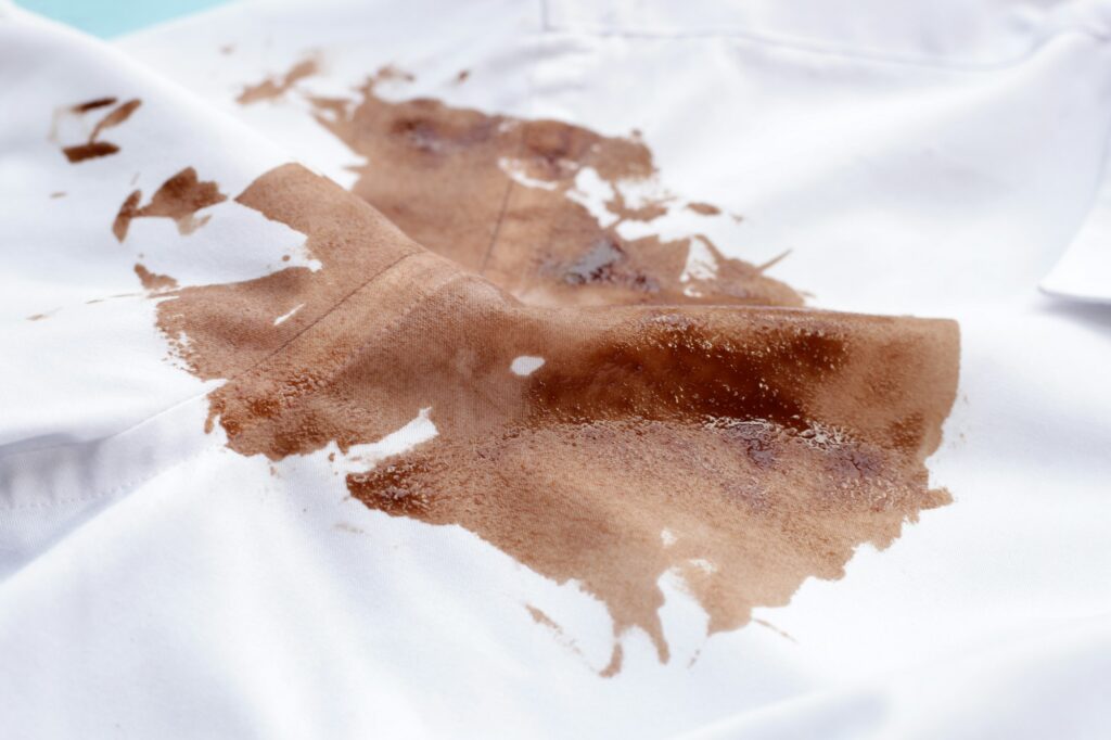 Mancha de chocolate sucio en camisa blanca