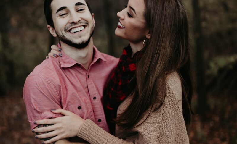 woman hugging man selective focus photography