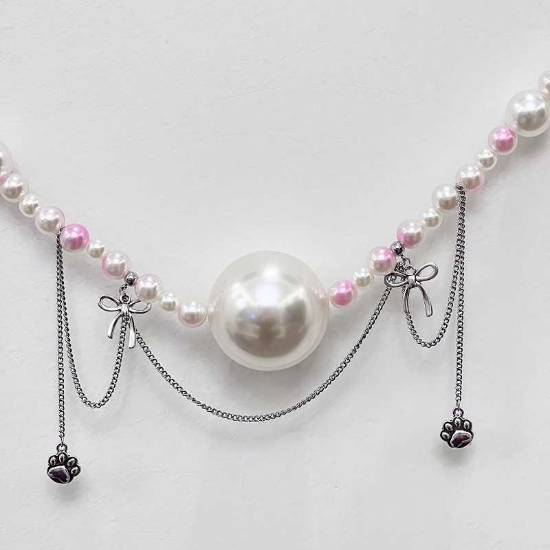 Elegante collana di perle con charms, con una grande perla bianca e accenti rosa.