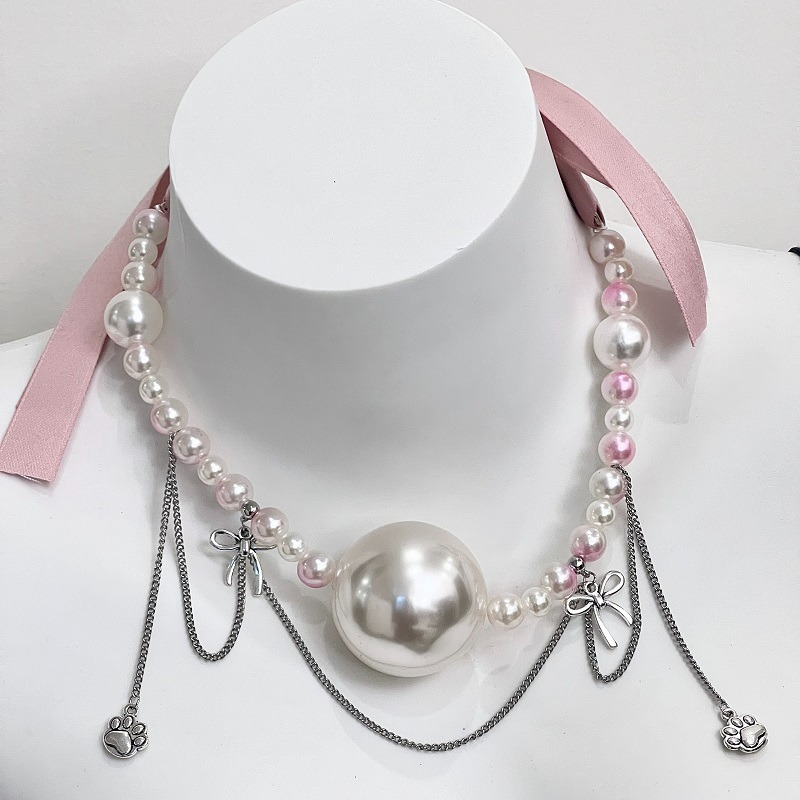 Elegant pearl necklace with charms and ribbons, perfect for any fashionable occasion.