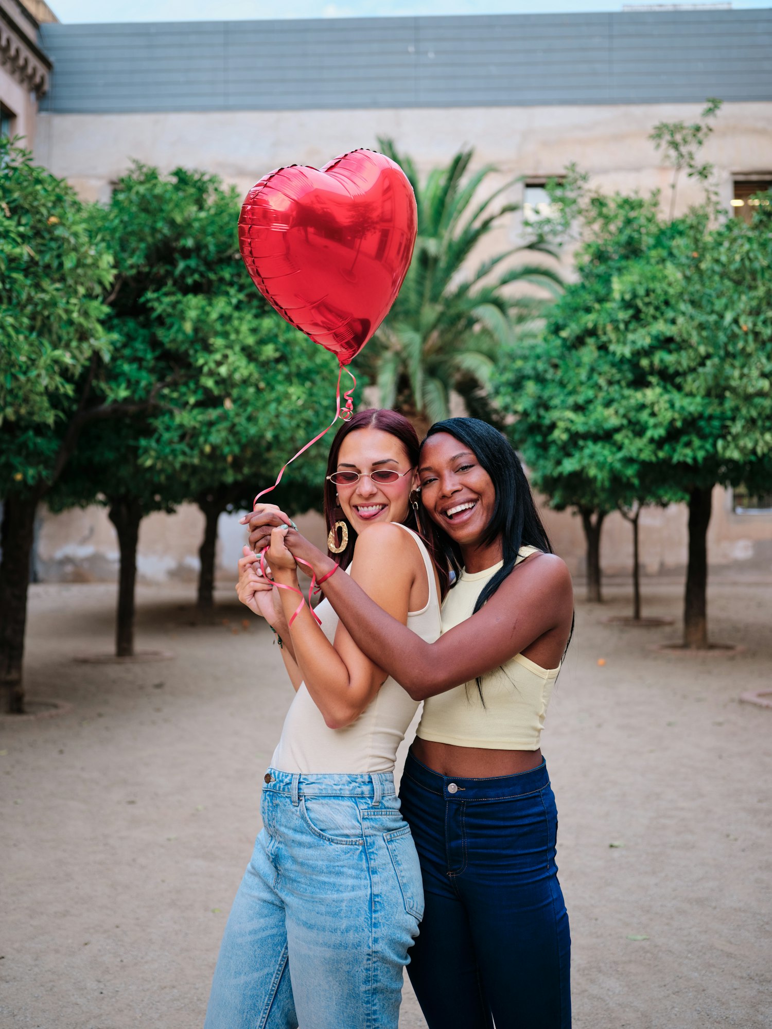 Coppia lesbica felice con un palloncino rosso a forma di cuore.