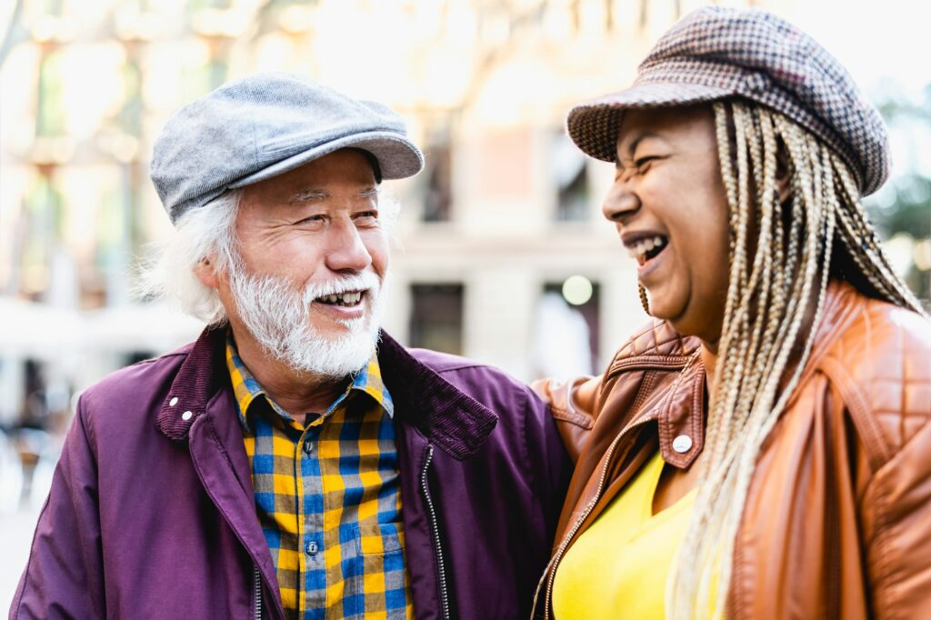 Happy multiracial senior couple having fun in city - Elderly people and love relationship concept