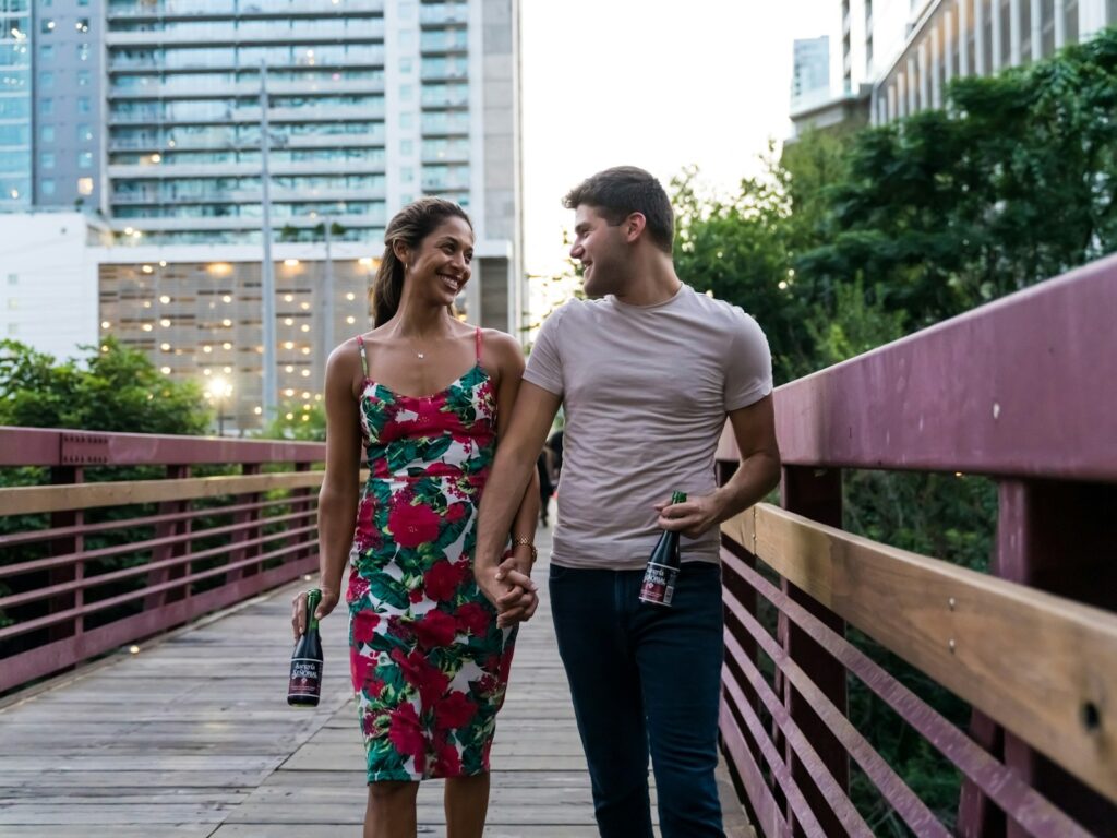 homem e mulher de pé numa ponte de madeira durante o dia