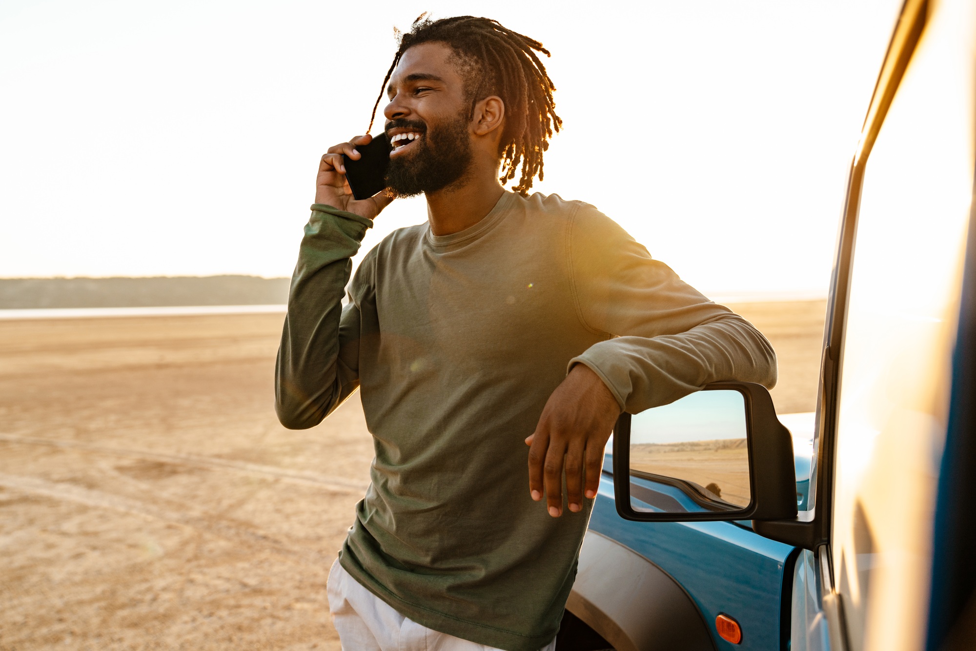 Billede af afroamerikansk mand, der taler i mobiltelefon, mens han rejser