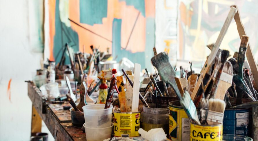 assorted-color paint brush on brown wooden table top