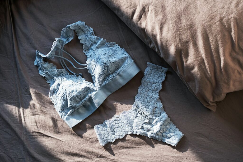 Lace Lingerie on Grey Bedsheets. Flat lay with Romantic Underwear.