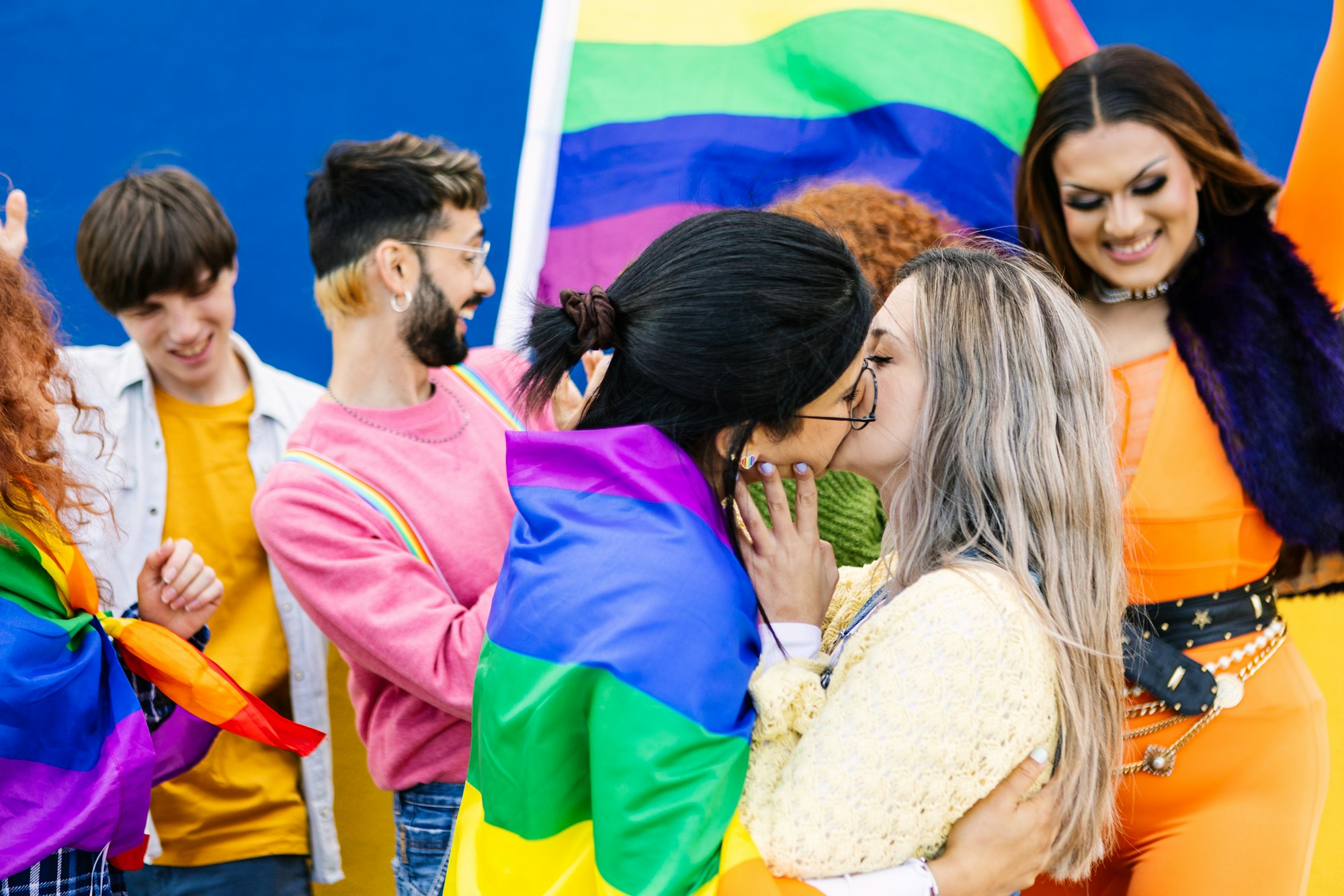 Ludzie ze społeczności LGBTQ z tęczową flagą świętują dzień dumy gejowskiej.