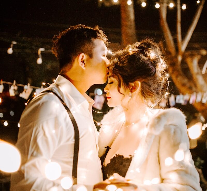 man kissing woman's forehead