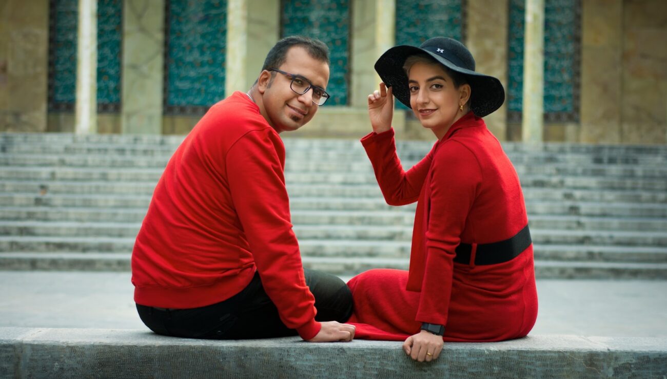 uomo in camicia a maniche lunghe rossa e nera e cappello nero