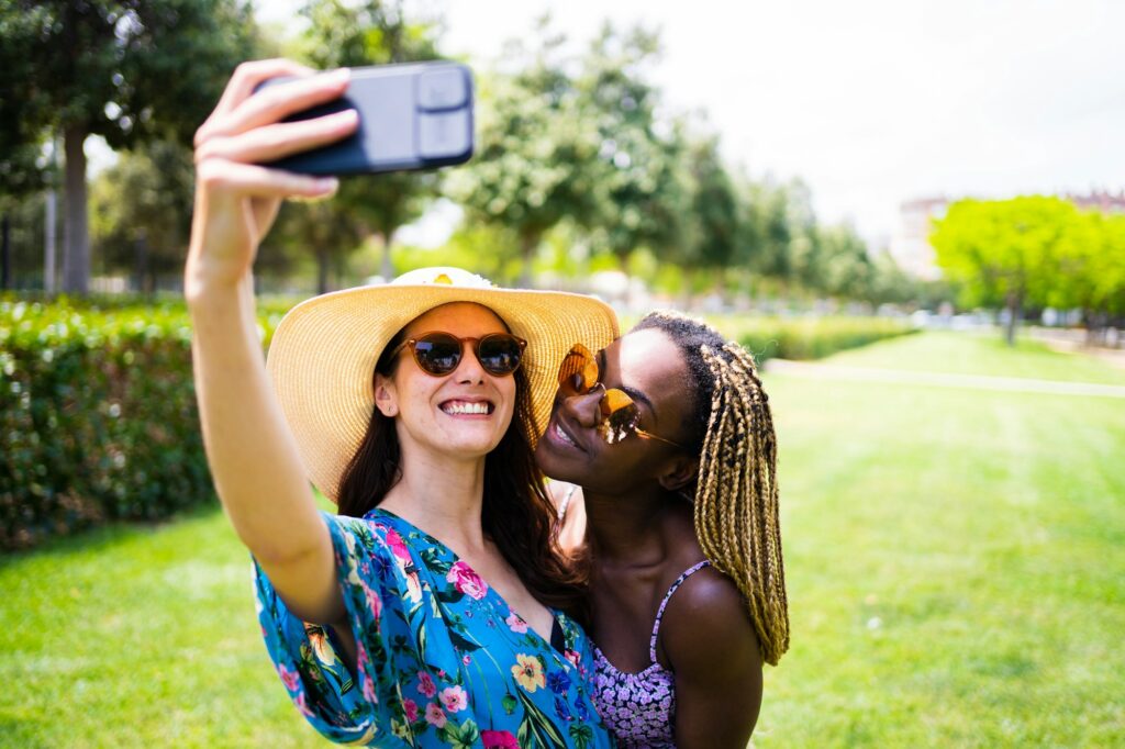 Multi-etnisch lesbisch stel neemt een selfie buiten