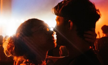 Intima ögonblick på en färgsprakande festival man och kvinna kysser varandra på natten