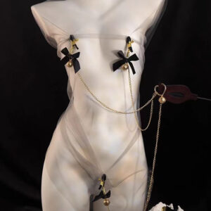 Sheer fashion outfit with gold accents and playful ribbons on a mannequin, showcasing bold elegance.