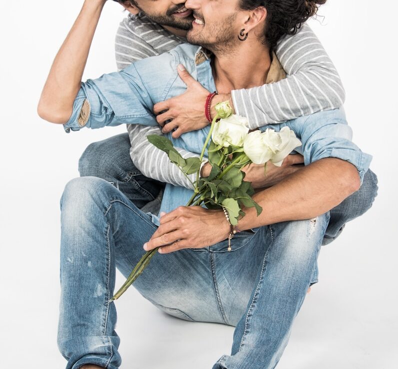 a man sitting on the ground holding a bouquet of flowers