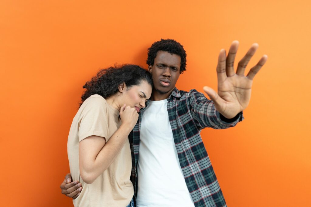 Young Couple Emotionally Distressed Seeking Comfort Orange Background