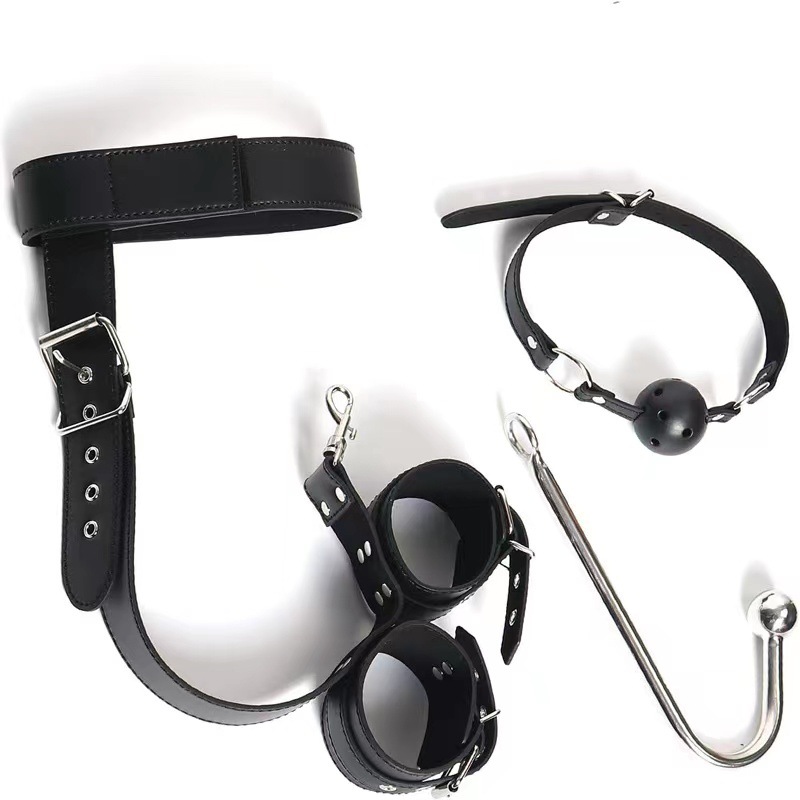 BDSM gear set with leather cuffs, straps, and a ball gag for bondage play.