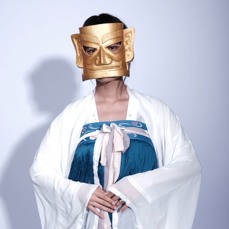 Etherische figuur in een gouden masker en elegante kleding, een mix van traditie en moderne allure.