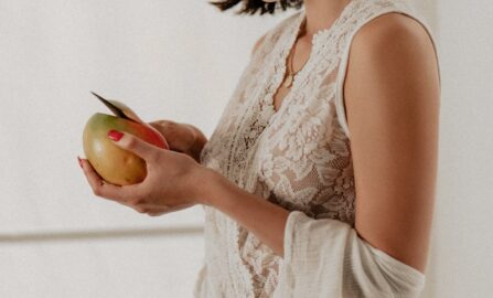 une femme en combinaison blanche tenant une pomme