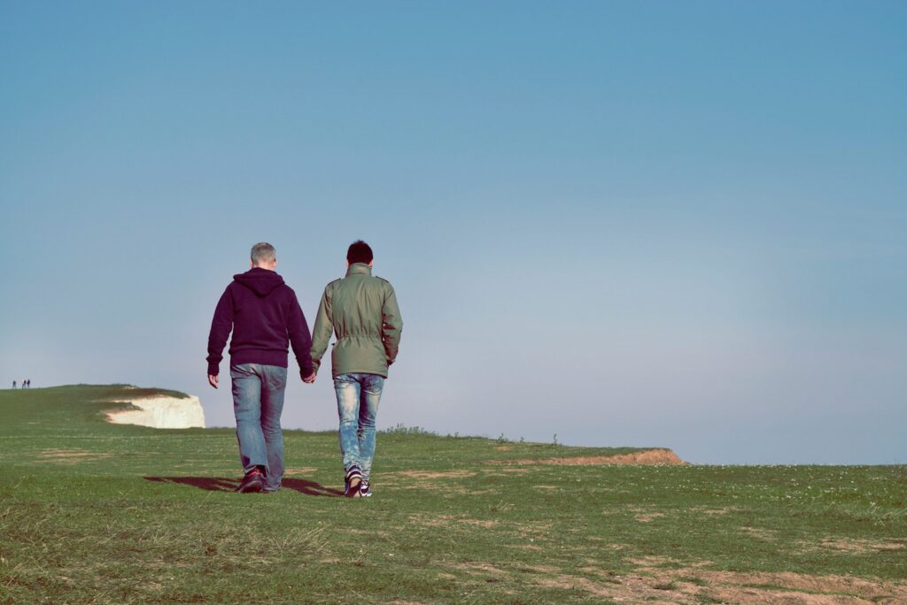 due persone che camminano su un campo di erba verde