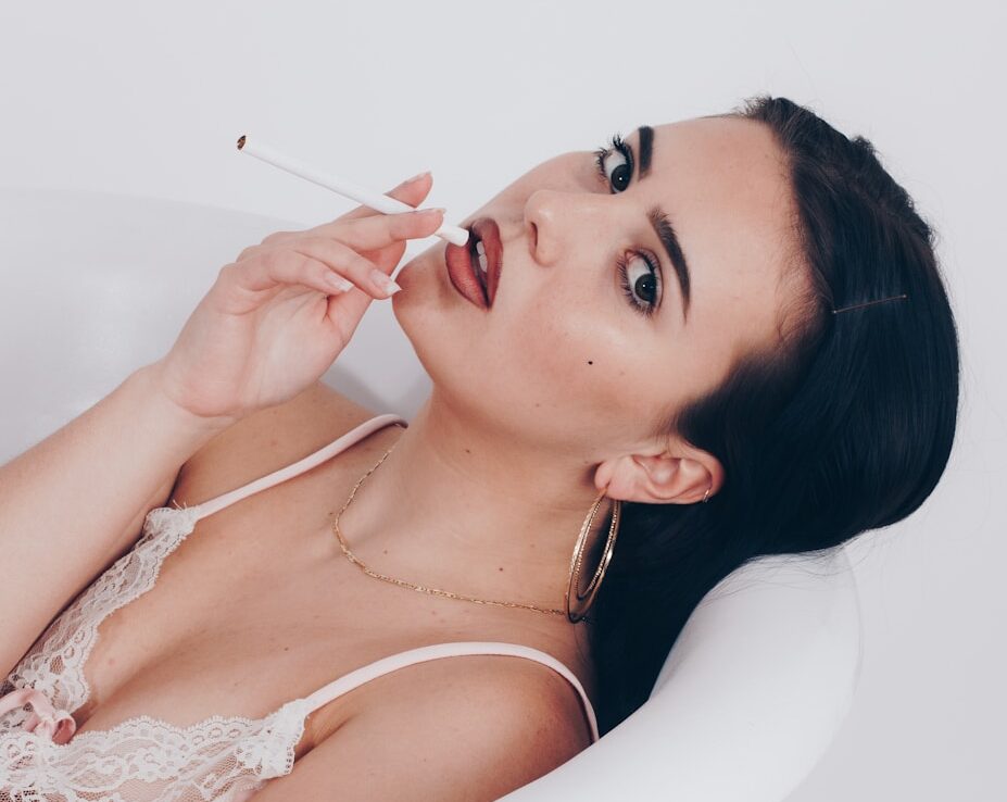 a woman in a bathtub with a cigarette in her mouth