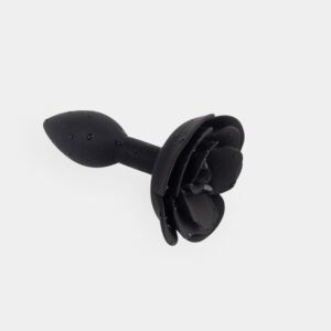 Elegante accesorio en forma de rosa negra con gotas de agua, perfecto para experiencias sensuales.