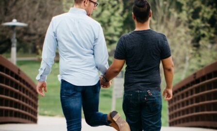 Mano nella mano: Un ponte di unione uomo in camicia bianca a maniche lunghe e jeans blu che si tiene per mano con donna in blu